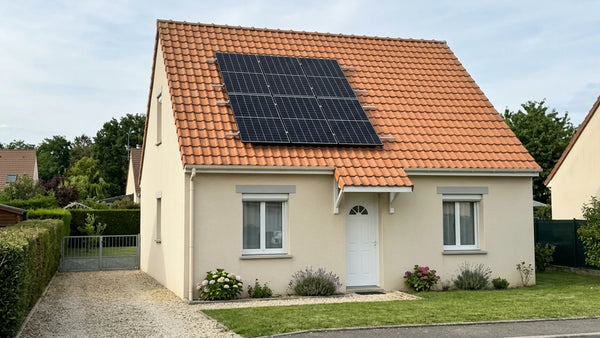 Maison individuelle française bien entretenue avec une petite installation de 6 panneaux solaires (3 kWc) en toiture — illustration de la TVA à 10 % ou 20 % sur le photovoltaïque en 2026